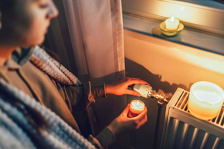 Hand turning radiator toggle switch at home. Shutdown of heating